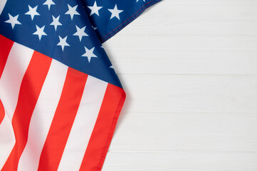 American flag fabric USA showing stars and stripes on a white wooden background, representing national identity, democracy, celebration space copy