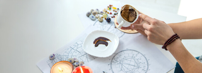 Tasseography: empty coffee cup, natal charts, runes and magic stones on table