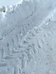 Traces of car tires in the snow, tread marks on snowdrifts in winter.