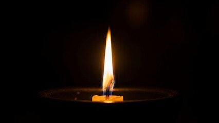Glowing candle flame flickers in dark room setting symbolizing remembrance and hope for peace soul