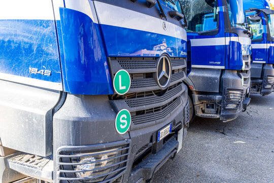 Naples, Italy: 10 January 2025: Series of blue Mercedes trucks parked in line, three big kargo vehicles on parking
