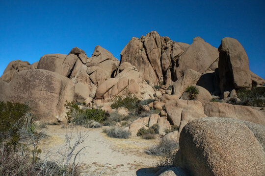 Massive rugged rock formations under deep blue desert sky