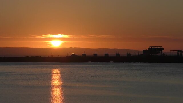 Calm Morning Sunrise over Cardiff Bay showing still water and the Barrage. Sun higher in the morning light.