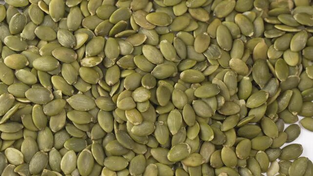 Green fresh Pumpkin seeds on a spoon.