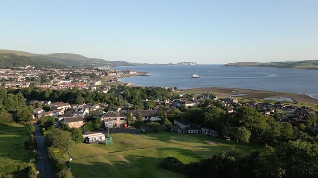 Aerial rise over Largs town houses and coastline in Scotland, UK