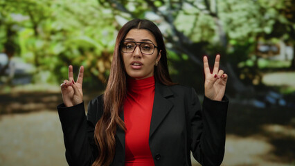 Woman outdoors wearing glasses and red top in a park setting during daytime