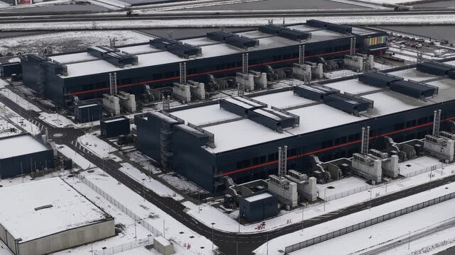 Aerial drone video of a large-scale computing and datacenter facility in winter, showcasing telecommunications infrastructure, server systems, and high-capacity digital operations.