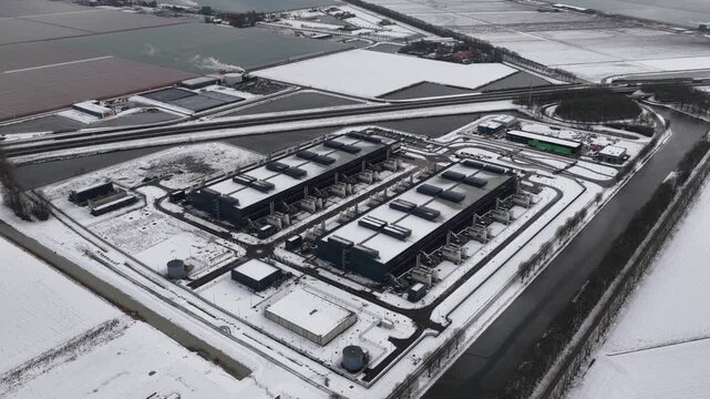 Aerial drone video of a large-scale computing and datacenter facility in winter, showcasing telecommunications infrastructure, server systems, and high-capacity digital operations.