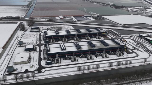 Aerial drone video of a large-scale computing and datacenter facility in winter, showcasing telecommunications infrastructure, server systems, and high-capacity digital operations.