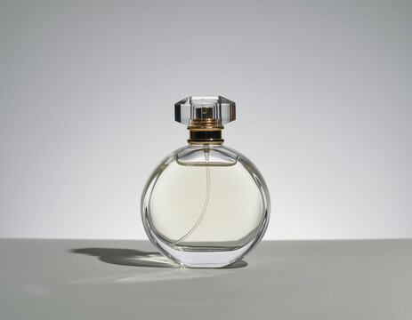 Round perfume bottle on neutral studio background
