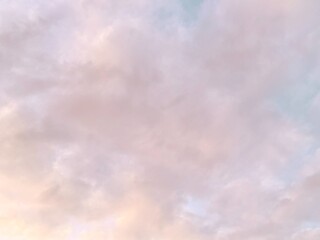 White clouds float in a orange sky; this can be used as a background image.