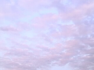 White clouds float in a purple sky; this can be used as a background image.