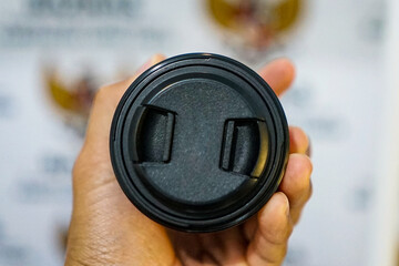 Fototapeta premium Camera lens held with blurred background