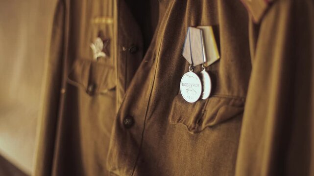 Close up detail view of Soviet military uniform, khaki fabric, shoulder straps of Red Army lieutenant, medals are on breast pocket, historical uniform from World War Two