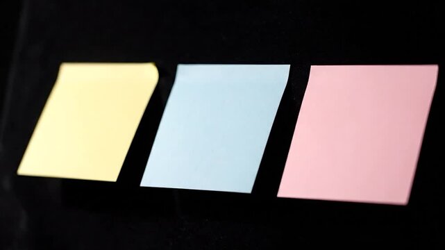 Three colored notes on a black surface