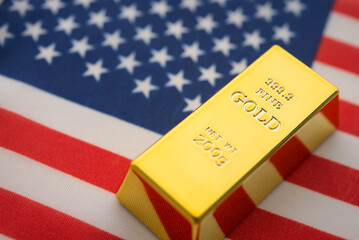 Gold bar with American flag background. FED Central bank of United states America keeps gold reserves, gold price increase, global finance and commodity trading market investment concept.