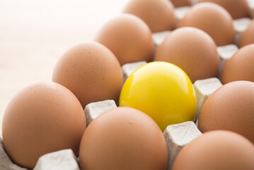 One special yellow egg in other normal eggs background. Think differently, standing out from the crowd, creative thinking ideas in business and marketing concept.