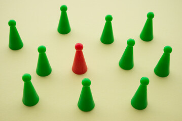 Unique red person standout from green crowd on yellow background. Uniqueness, make difference, think outside the box, leadership management and business strategy concept.