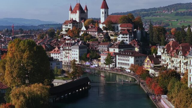 Thun Castle Schloss Thun Thunersee Switzerland Schweiz Europe aerial drone Autumn Fall Aare River pedestrian walkway sunny blue sky clouds yellow birches tree Bernese Oberland forward pan up motion