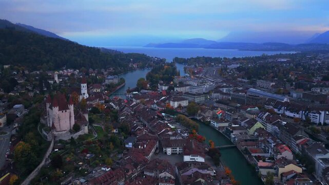 Thun Castle Flusswelle Aare River aerial drone view Schloss Thun Thunersee Switzerland Schweiz Europe Autumn Fall morning grey skies buildings yellow birches tree walkway Bernese Oberland circle right