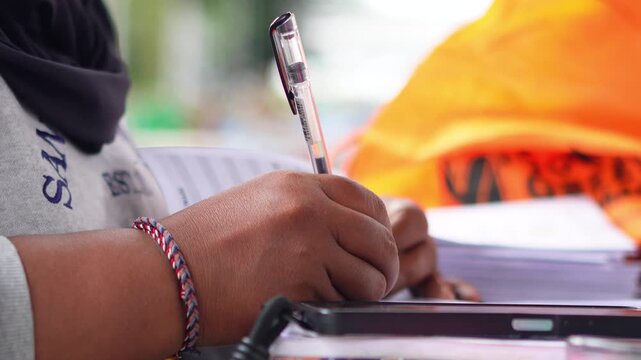 A person counting numbers and writing notes on paper, focused on calculation, planning, or financial work