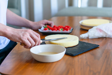 出来合いのスポンジを使ってショートケーキを作る男性