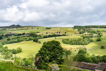 Obraz premium Patchwork of green fields and moorland slopes surrounding Haworth, a landscape long associated with the Bronte sisters, Haworth, United Kingdom.