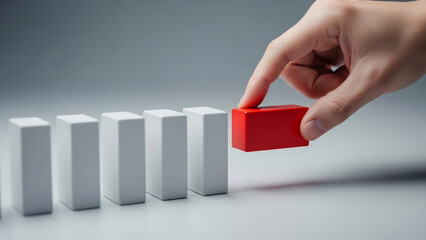 Hand Carefully Places Red Domino Among White Ones