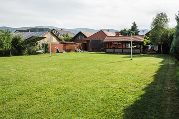 Nicely trimmed front yard with green grass in front of a summer cottage.