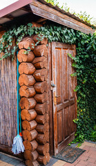 Garden wooden shed front view with mop on a corner.