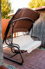 Garden swing in a backyard on a warm summer day.