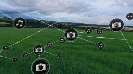 Music and camera icons connected by lines, network animation over green landscape - Powered by Adobe