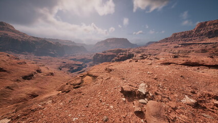 Vast expanse of rugged terrain unfolds under a bright sky. The warm hues of the rocks contrast with...
