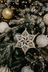 A white star-shaped toy is attached to a Christmas tree decorated with garlands