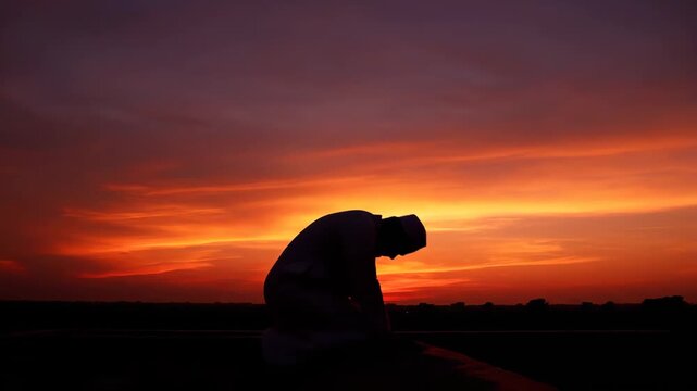Silhouette of Muslim Praying at Sunset