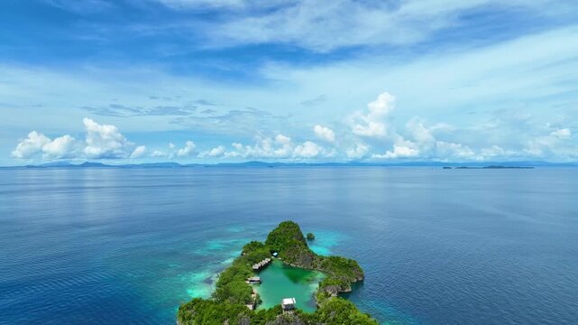 Aerial view of island paradise featuring a vibrant turquoise lagoon with in limestone cliffs at Raja Ampat Islands, Indonesian archipelago, West Papua, Indonesia