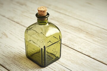 A clean product photography shot of an empty emerald green glass bottle