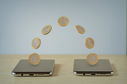 Coins moving from one smartphone to an other - Concept of digital money transaction