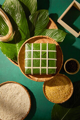 Banh chung centered among sticky rice, mung beans and leaves in clean flat lay. Ideal for food...