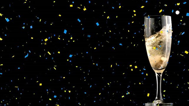 Animation of yellow and blue confetti falling over champagne glass against black background