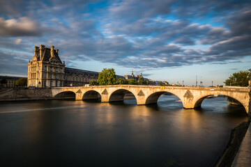 Fototapeta premium Paysage urbain de Paris avec un pont sur la Seine conduisant jusqu'au musée du Louvre