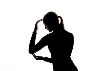 A backlit silhouette of a woman with her hands forming a frame around her face, against a white background with copy space. No visible logos or trademarks