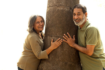Indian Senior happy couple enjoying in park. Elderly couple embracing, spending time and having fun in vacation time. Senior citizens care hugging or date at the park for romance after retirement. Sen © Pix4Ads