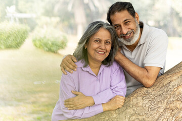 Indian Senior happy couple enjoying in park. Elderly couple embracing, spending time and having fun in vacation time. Senior citizens care hugging or date at the park for romance after retirement. Sen © Pix4Ads