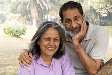Indian Senior happy couple enjoying in park. Elderly couple embracing, spending time and having fun in vacation time. Senior citizens care hugging or date at the park for romance after retirement. Sen © Pix4Ads