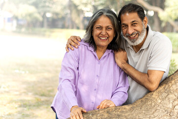 Indian Senior happy couple enjoying in park. Elderly couple embracing, spending time and having fun in vacation time. Senior citizens care hugging or date at the park for romance after retirement. Sen © Pix4Ads