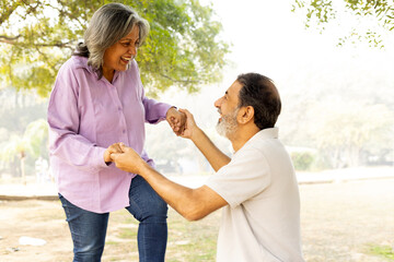 Indian Senior happy couple enjoying in park. Elderly couple embracing, spending time and having fun in vacation time. Senior citizens care hugging or date at the park for romance after retirement. Sen © Pix4Ads