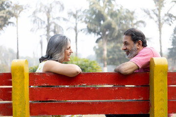 Indian Senior happy couple enjoying in park. Elderly couple embracing, spending time and having fun in vacation time. Senior citizens care hugging or date at the park for romance after retirement. Sen © Pix4Ads