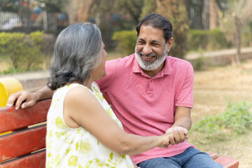 Indian Senior happy couple enjoying in park. Elderly couple embracing, spending time and having fun in vacation time. Senior citizens care hugging or date at the park for romance after retirement. Sen © Pix4Ads