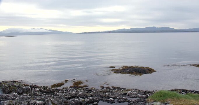 Wide shot of Ganavan beach and Bay with black Highland midges at Oban